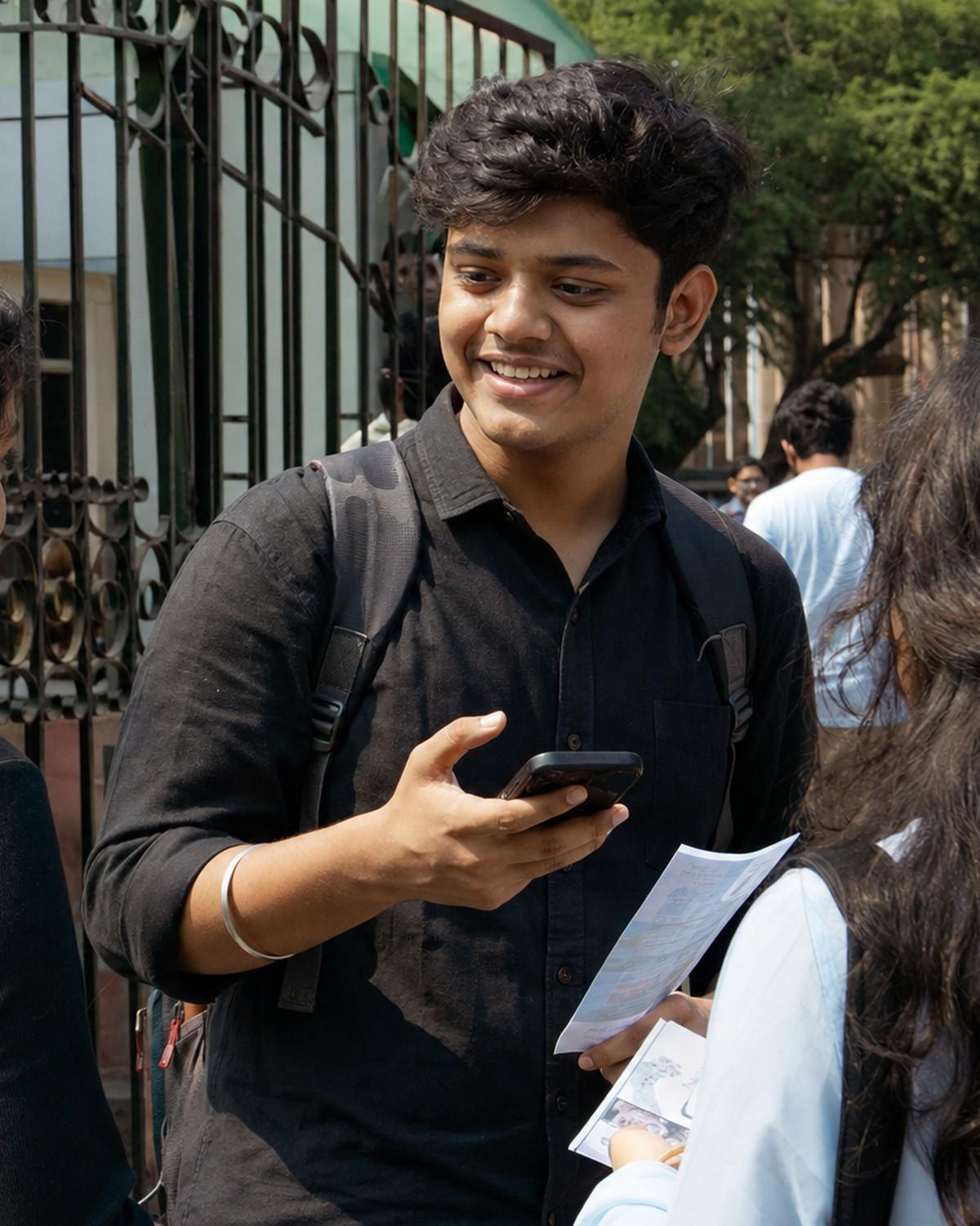 A young Nomio field teammate at a college gate with a flyer