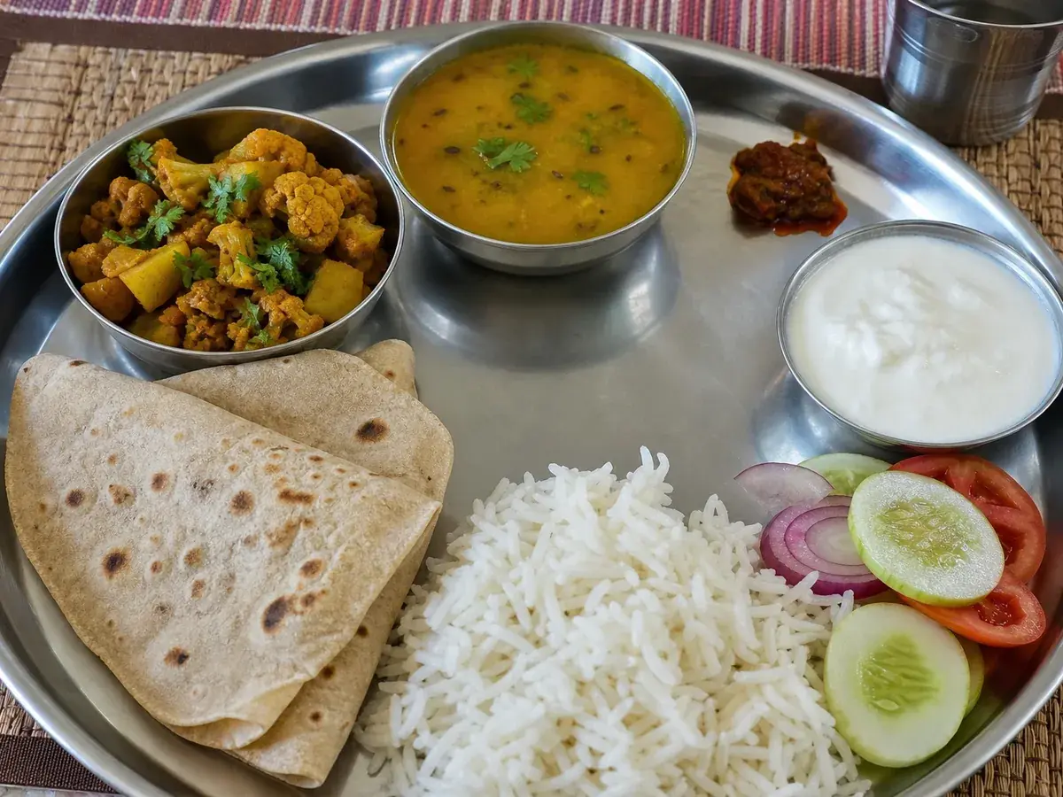 Home-cooked vegetarian thali with dal, sabzi, roti, rice and salad delivered by a Nomio home chef